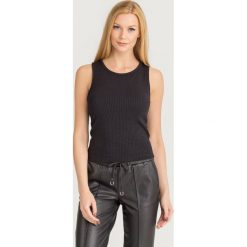 TOP JECKIE CROP GUESS. Czarne topy Guess, l, z aplikacjami, z materiału, bez kołnierzyka, bez ramiączek. Za 99.00 zł.