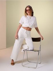 Jeansy wide leg mid waist z ażurowym wykończeniem nogawki - kremowy. Białe jeansy Sinsay, w ażurowe wzory. Za 59.99 zł.