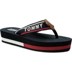 Japonki TOMMY JEANS - Mid Beach Sandal EN0EN00069 Tommy Navy 406. Niebieskie klapki Tommy Jeans, bez wzorów, z jeansu, bez obcasa. W wyprzedaży za 129.00 zł.