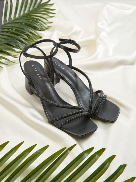 Sandały - czarny. Czarne sandały Sinsay, bez wzorów, bez obcasa, na obcasie, bez zapięcia. Za 79.99 zł.