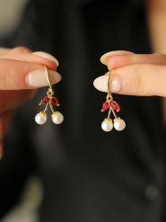 Pierres de Jade Pozłacane kolczyki z perłami i cyrkoniami rozmiar: onesize. Białe kolczyki Pierres de Jade, z cyrkonią, pozłacane, z zapięciem typu bigiel. Za 43.99 zł.