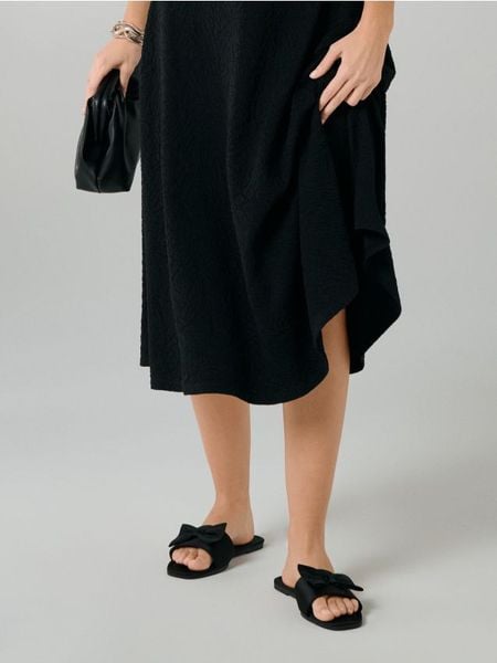 Klapki z kokardą - czarny. Czarne klapki Sinsay, bez wzorów, bez obcasa. Za 29.99 zł.