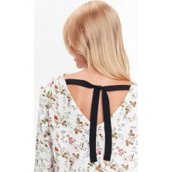BLUZKA W KWIATOWY NADRUK Z WIĄZANIEM NA PLECACH. Białe bluzki TOP SECRET, bez wzorów, eleganckie, bez kołnierzyka, bez ramiączek. W wyprzedaży za 29.99 zł.